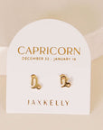 gold earrings in the shape of the capricorn zodiac sign