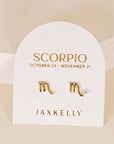 gold earrings in the shape of the scorpio zodiac sign