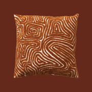 An orange and cream tufted design pillow.