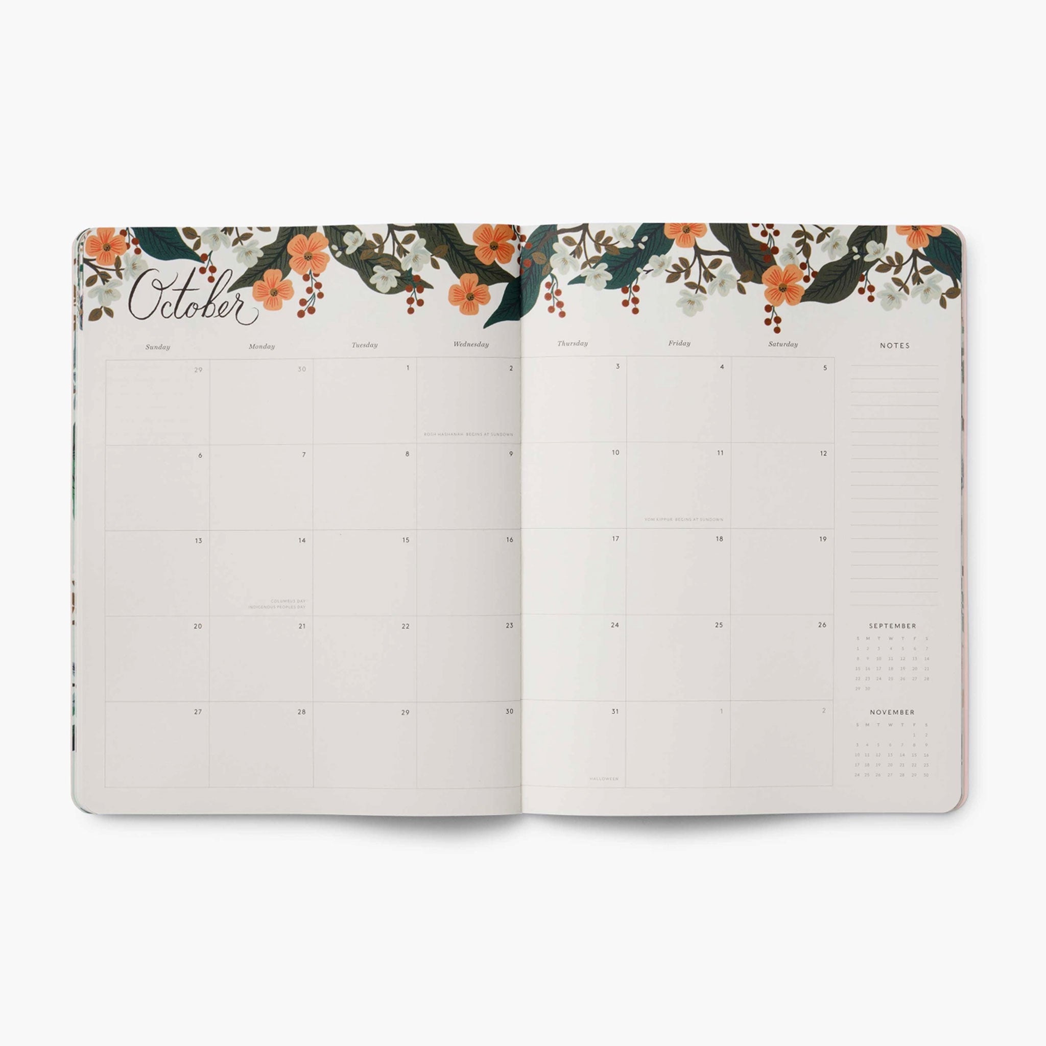 The planner opened to a page showing a monthly view with a floral border at the top. 