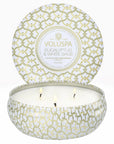 A round three wick candle in a white and gold cross design tin.