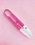 Mini bright pink planting shears are shown against a light pink background.