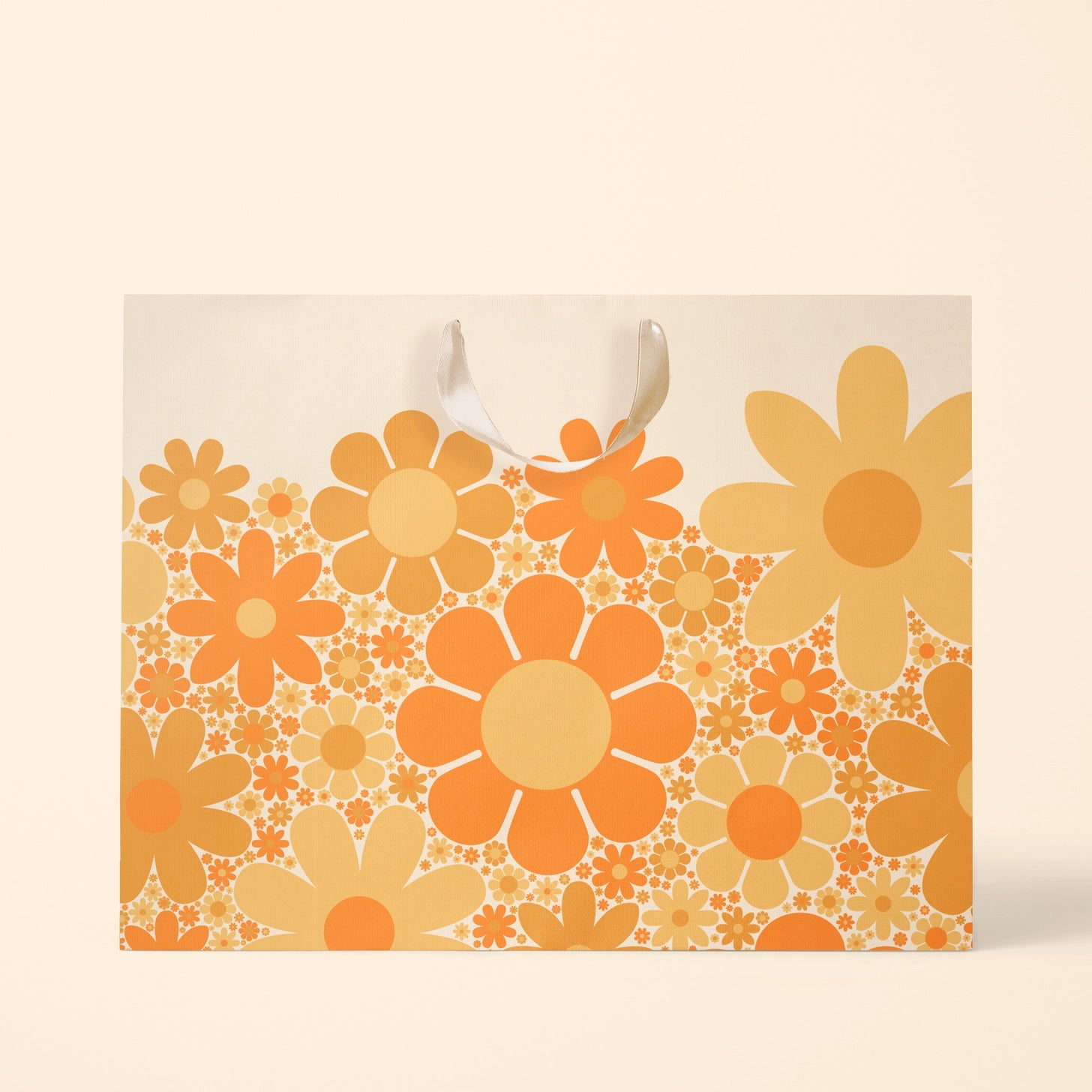 On a cream background is an ivory gift bag with a yellow and orange daisy pattern. 