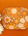 A metal tray perfect for rolling or all your favorite trinkets. It features a 70's inspired floral design with a variation of daisies in different shapes, sizes and colors.