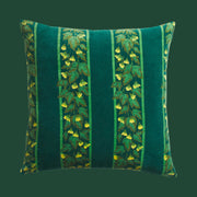 A square pillow with a green and teal floral pattern.