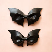 A pair of leather bath shaped hair bows.