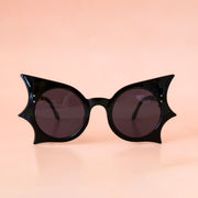 A black pair of sunglasses with a bat shape.
