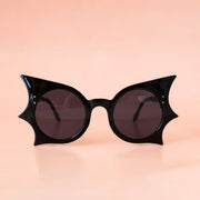 A black pair of sunglasses with a bat shape.