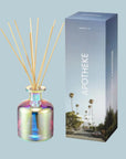 A glass reed diffuser with wooden reeds.