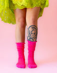 A pair of fuchsia colored striped socks with a ruffle detail at the top.