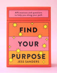An orange, yellow and pink deck of cards with the words, "Find Your Purpose" on the front as well as "Affirmations and questions to help you along your path" in black writing.