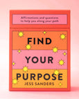 An orange, yellow and pink deck of cards with the words, "Find Your Purpose" on the front as well as "Affirmations and questions to help you along your path" in black writing.