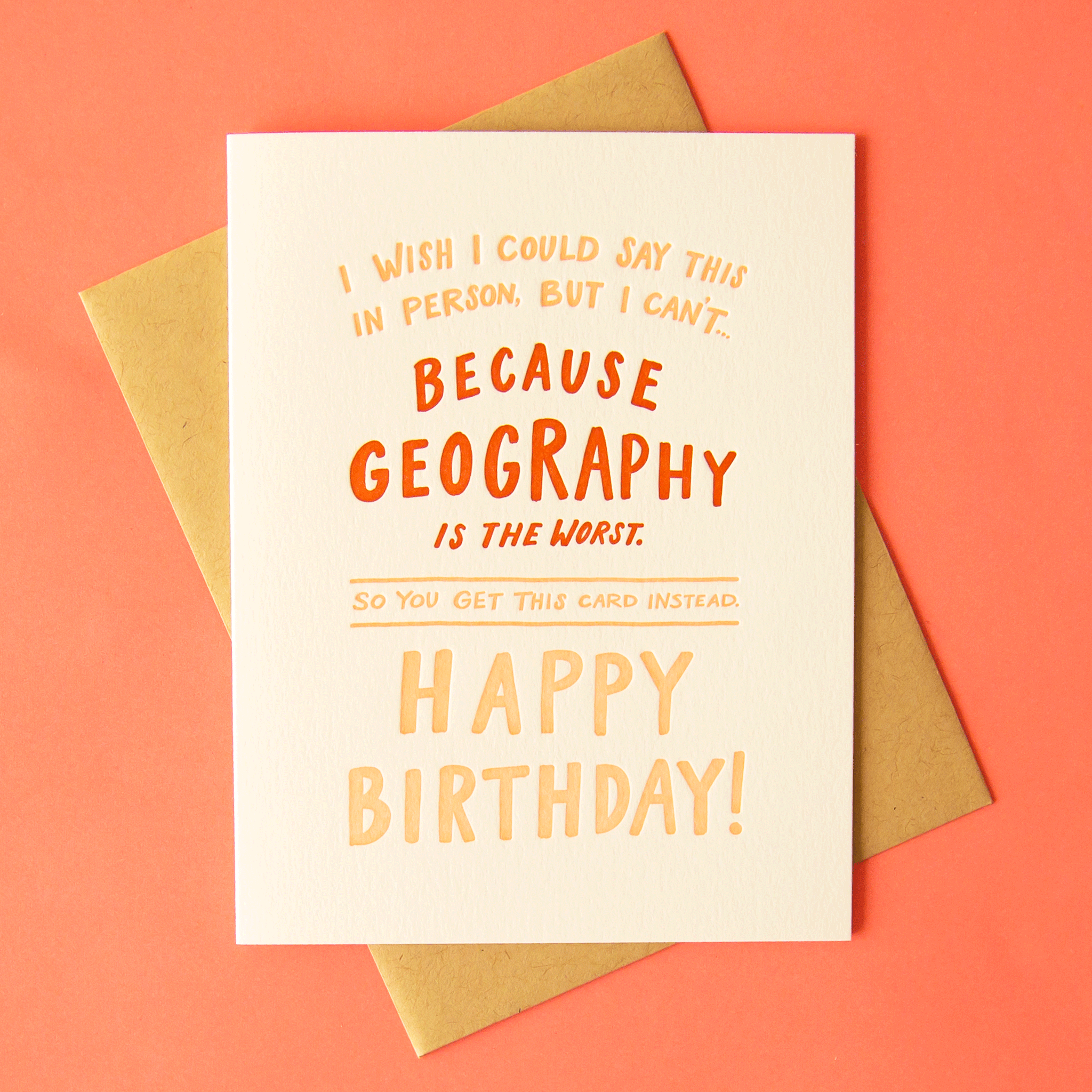 A white card with pink and red text on the front that reads, "I wish I could say this in person, but I can't... Because geography is the worst. So you get this card instead. Happy Birthday!". Also included is the coordinating light pink envelope.