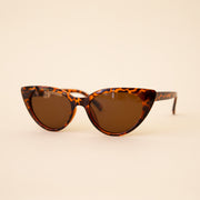 A brown tortoise print pair of cat-eye shaped sunglasses.