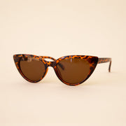 A brown tortoise print pair of cat-eye shaped sunglasses.