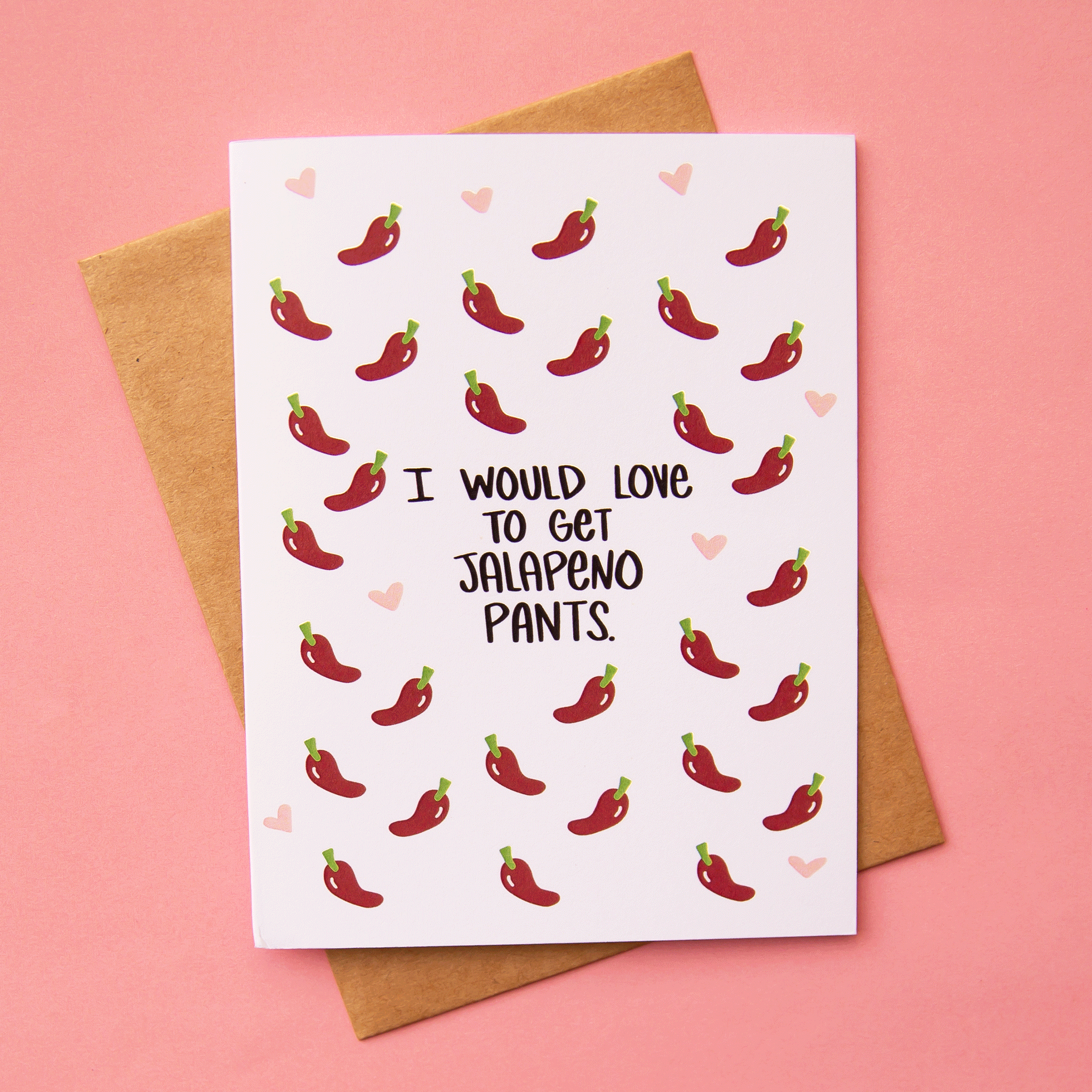 On a pink background is a white card with red peppers and black text in the center that reads, &quot;I Would Love To Get Jalapeno Pants.&quot;.