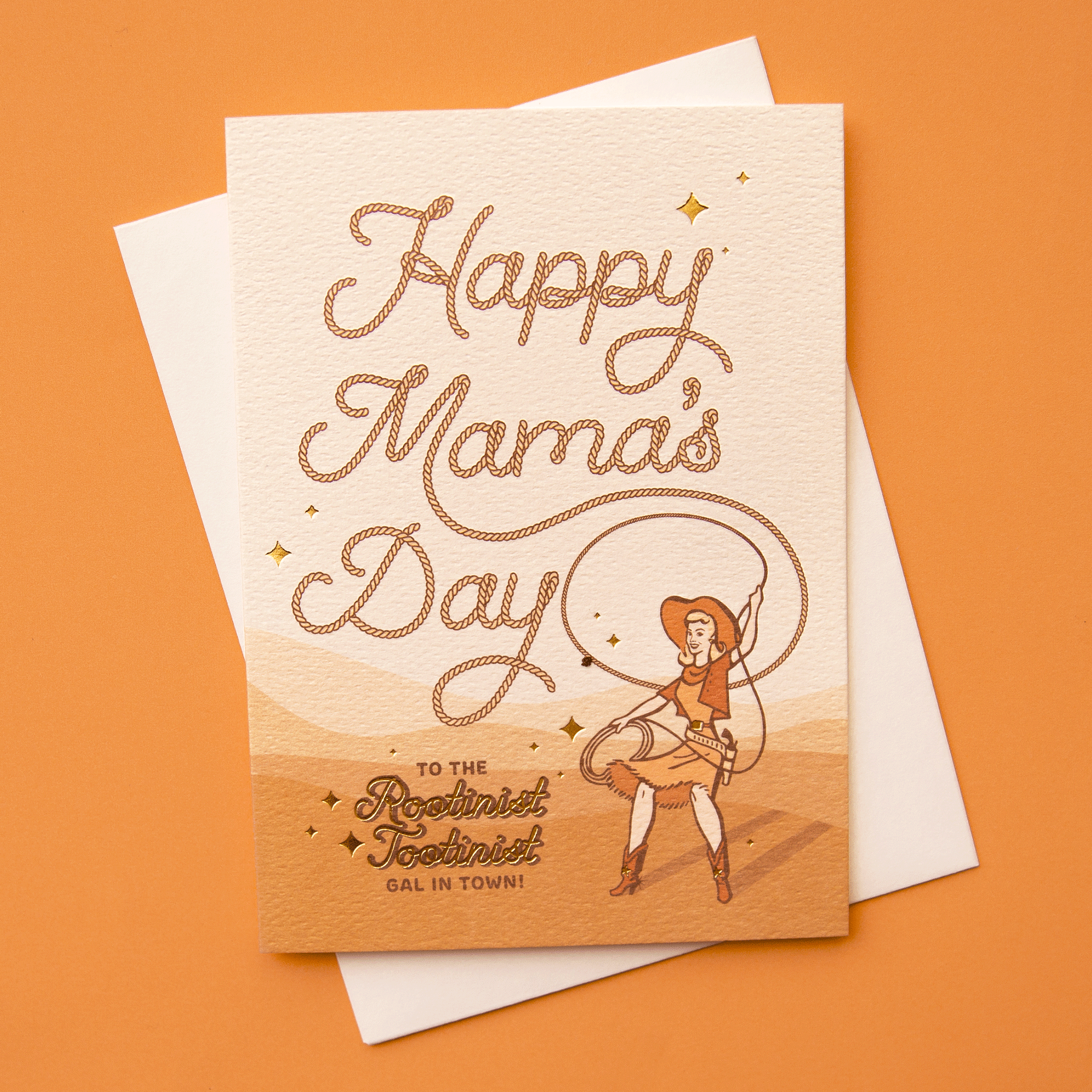 On an orange background is a orange and tan card with rope styled text that reads, &quot;Happy Mama&#39;s Day To The Rootinist Tootinist Gal In Town!&quot; along with a women with a cowgirl hat and lasso. 