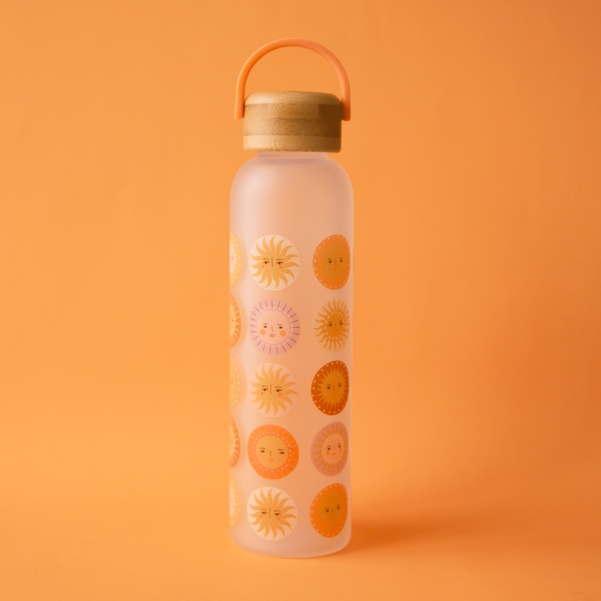 On an orange background is a water bottle with various sun patterns and a wood lid with an orange loop for carrying. 