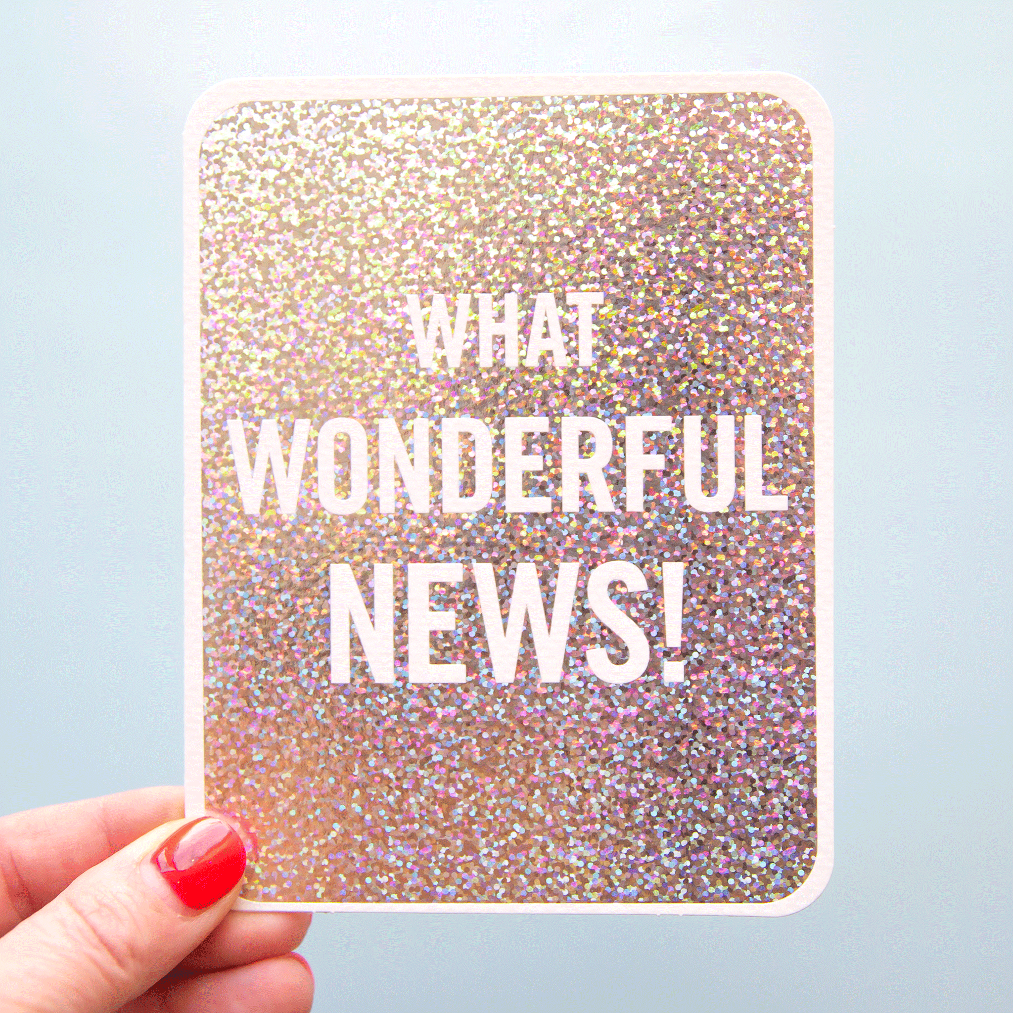On a blue background is a silver card with white text that reads, &quot;What Wonderful News!&quot;.