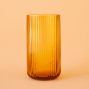 An amber ribbed glass tumbler.