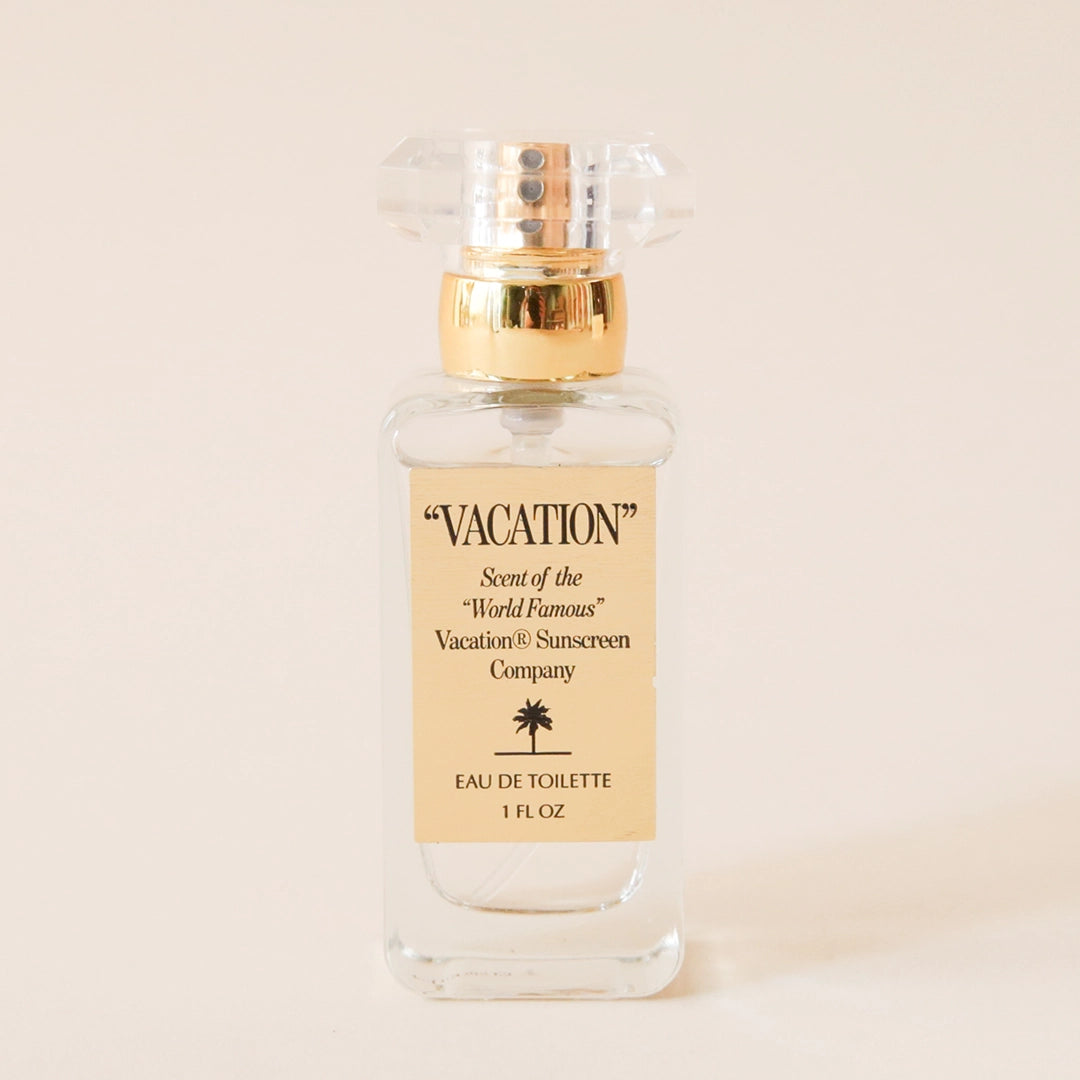 Glass perfume bottle that reads &#39;Vacation, Scent of World Famous Vacation Sunscreen Company&#39; across the front label. The bottle is topped with a glass knob lid