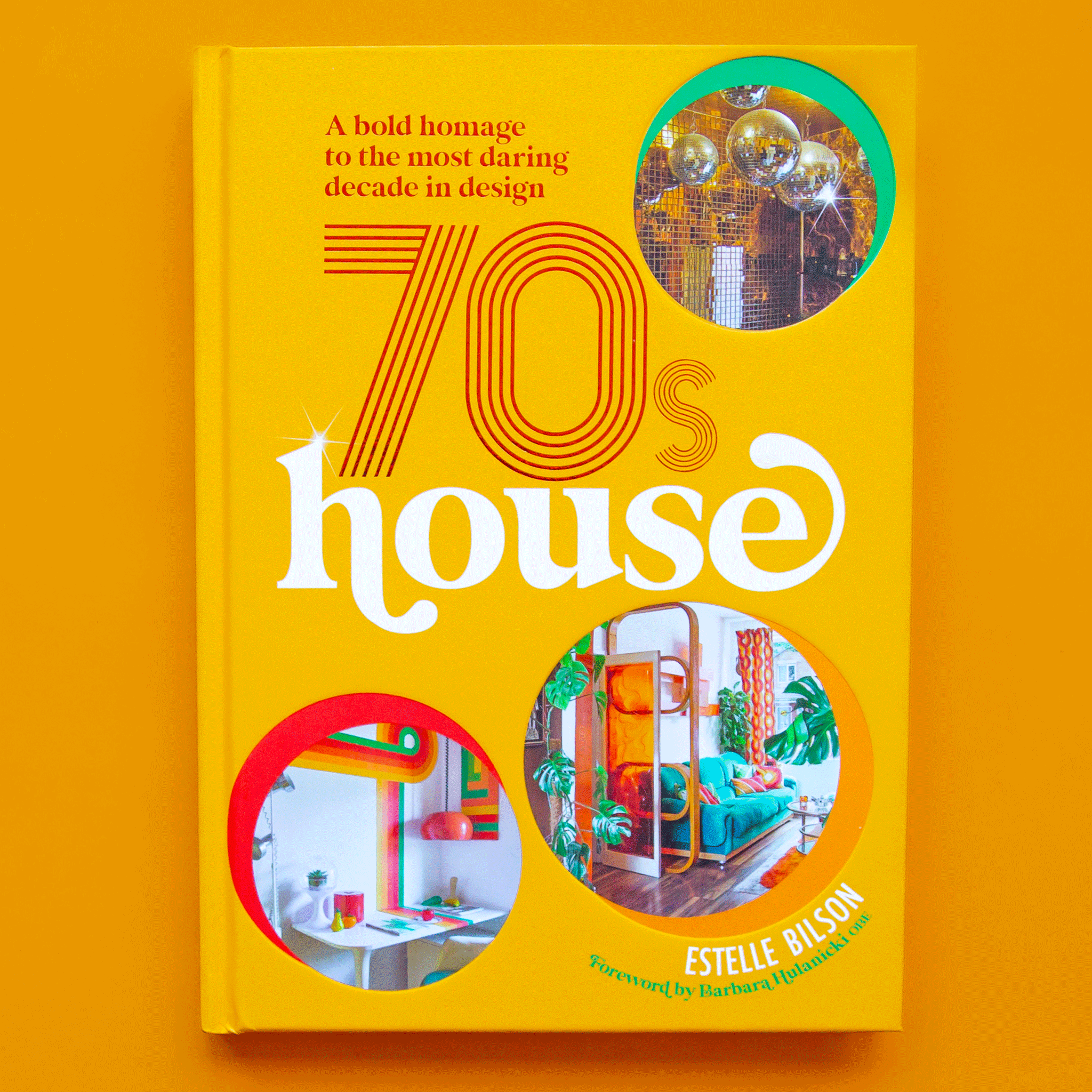 On a yellow background is a yellow book with circle photos of disco balls, and retro home decor as well as the title that reads, &quot;A bold homage to the daring in design 70s house&quot;. 