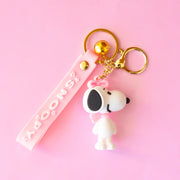 A snoopy shaped keychain with a pink lanyard that reads, "Snoopy".