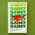 On a green background is a white book with green repeated text that reads, "saucy" and a spoon graphic with a sauce drizzling off it. 