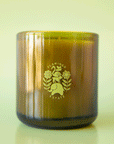 On a green background is a green glass jar candle with a logo in the center that reads, "Flamingo Estate".