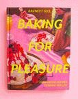 On a pink background is a hot pink book cover with desserts on the front and yellow text that reads, "Baking For Pleasure".