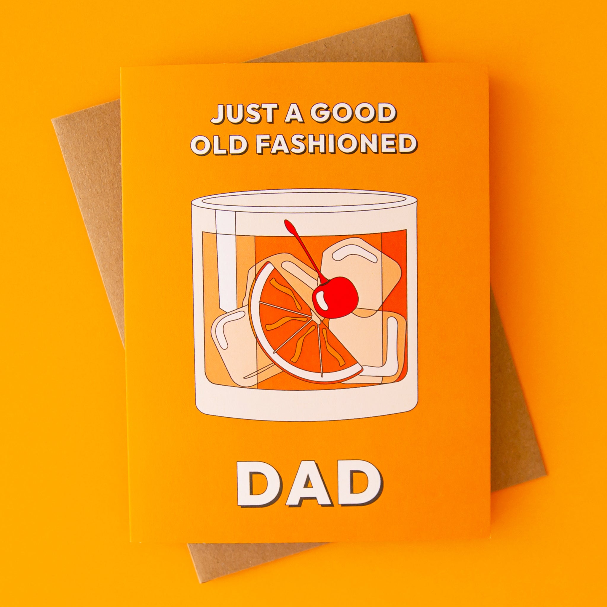 On an orange background is an orange card with artwork of an old fashioned cocktail with text above and below that reads, &quot;Just A Good Old Fashioned Dad&quot;. 