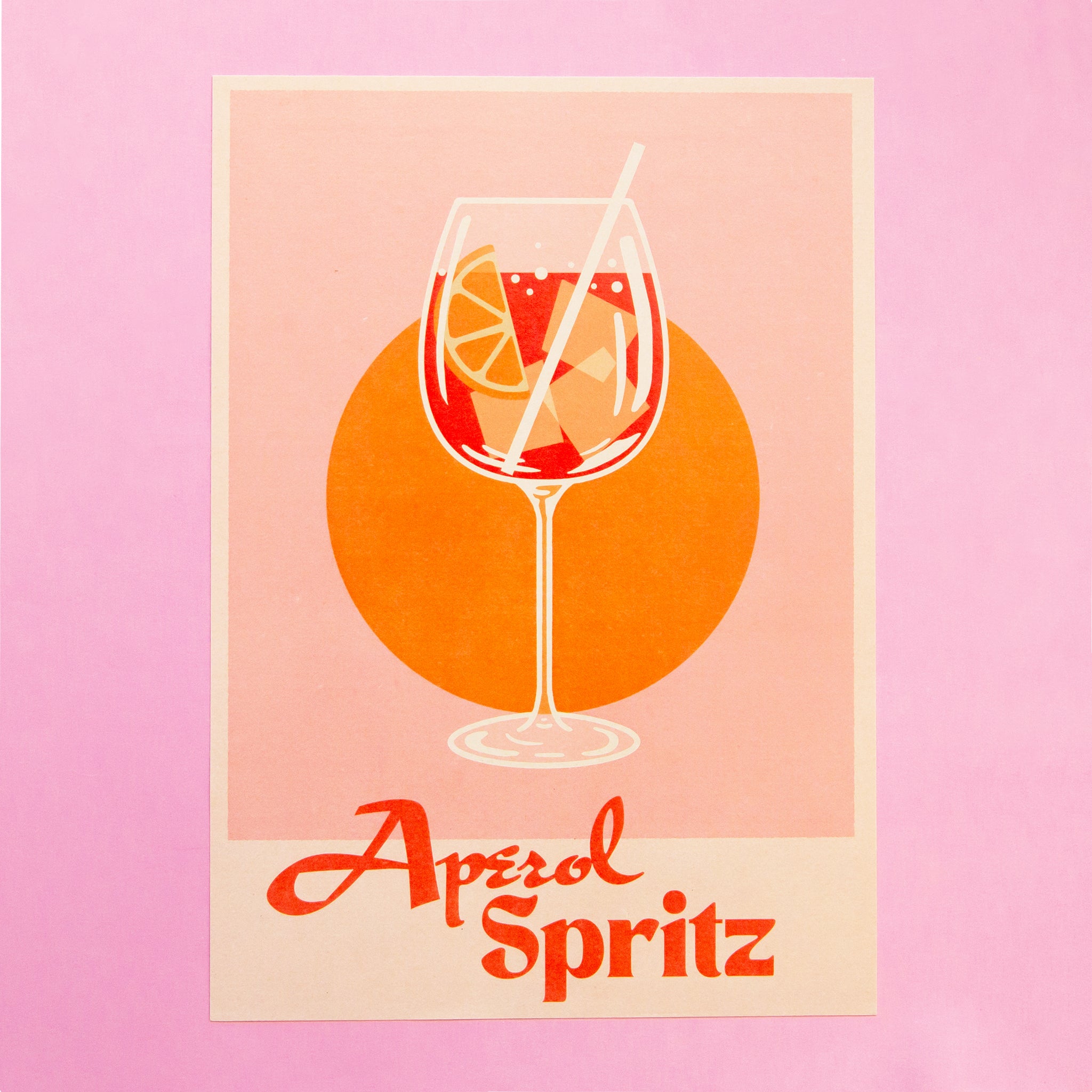 An aperol spritz cocktail illustration with an orange wedge in the glass sits on a pink background with orange circle. text reads aperol spritz.