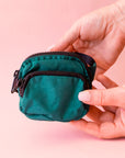 A cypress green colored fanny pack bag charm with black zippers and details.