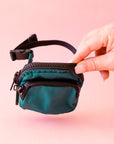 A cypress green colored fanny pack bag charm with black zippers and details.