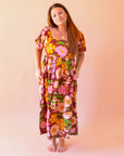 A mutli colored floral print maxi dress with puff sleeves and pockets. A mutli colored floral print maxi dress with puff sleeves and pockets.