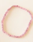 On a neutral background is a pink tourmaline beaded bracelet.