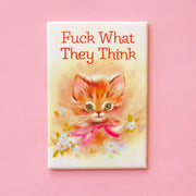 On a pink background is a magnet with an illustration of a kitten and florals around it and text above that reads, "Fuck What They Think".