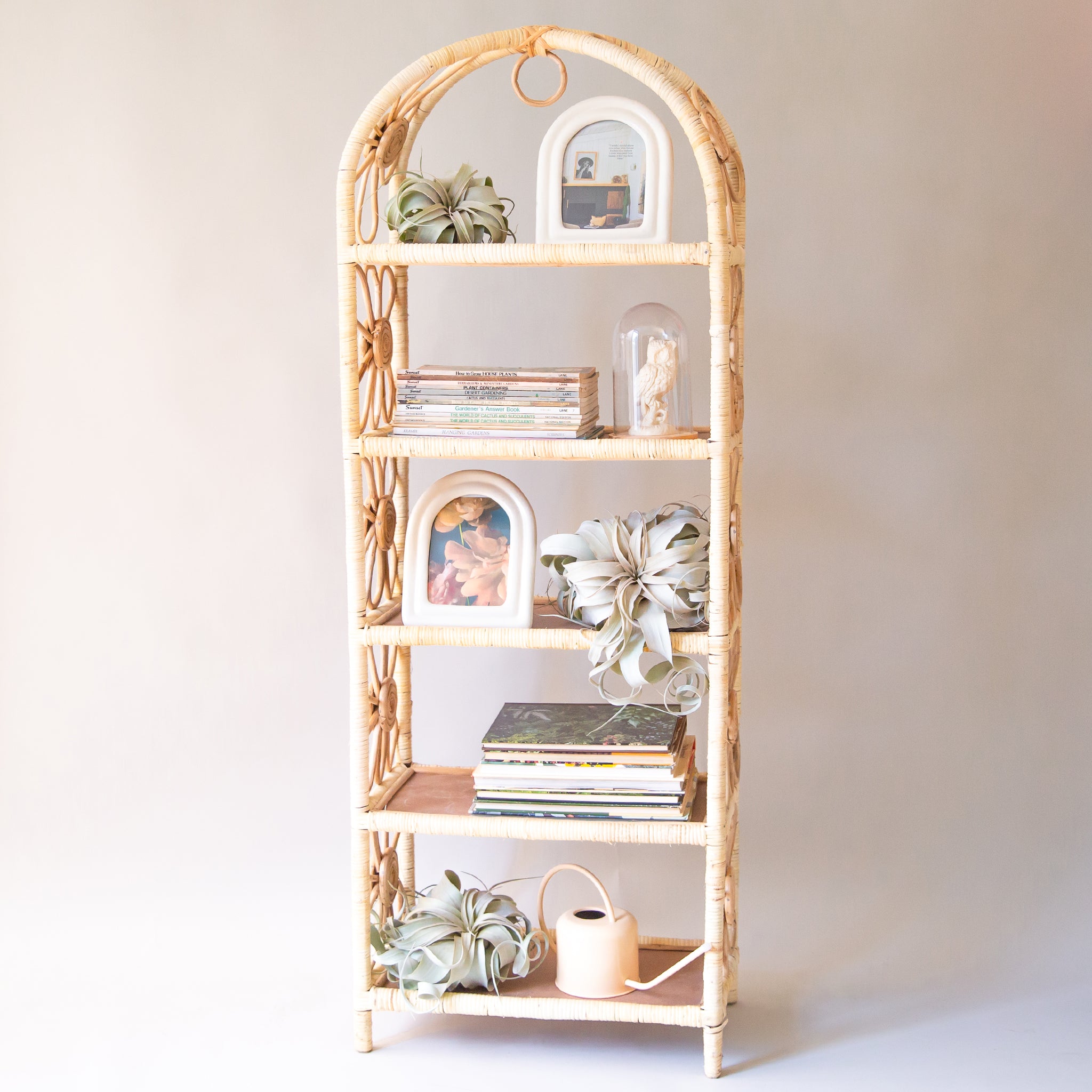 The large version of the shelf. Natural woven rattan shelf with daisy accents on both sides. The sides are open and let in ample light to keep the shelves well lit. Each shelf is covered in rattan and has a chocolate brown bottom.