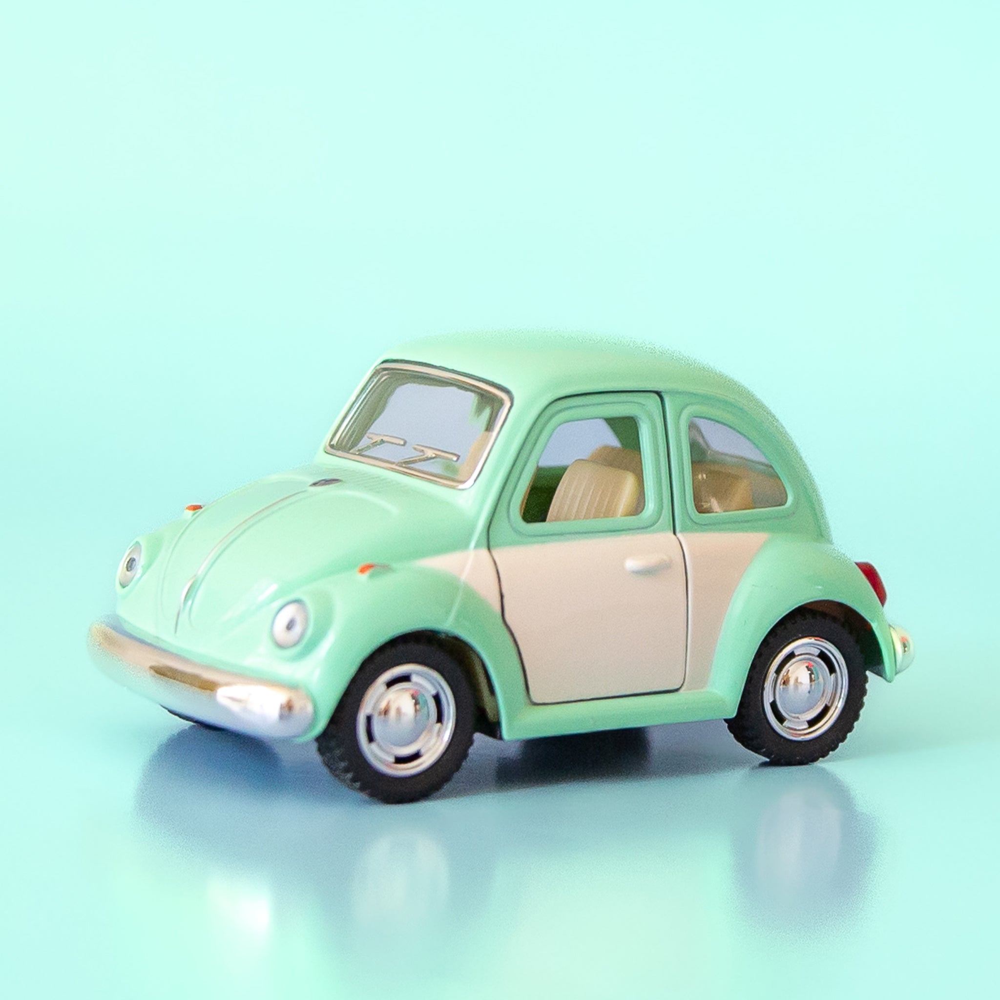 A green and white metal toy car volkswagen beetle. 