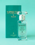 A box of perfume and a clear bottle with a teal blue label on the front that reads, "After Sun Scent of the Illustrious".