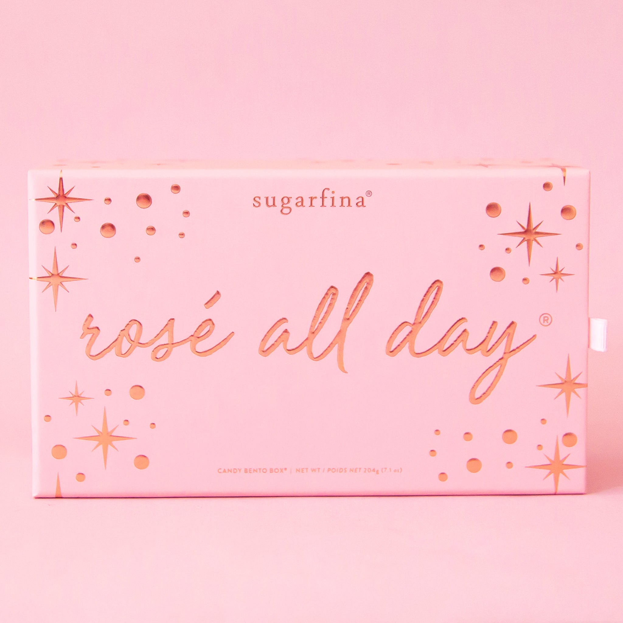 In front of a light pink background is a light pink rectangular box with a rose gold border and rose gold polka dots. In the middle is rose gold script text that reads ‘rosé all day.’