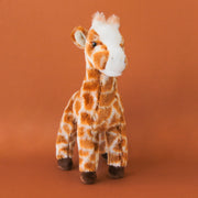 A brown and white giraffe stuffed animal toy with chocolate brown hooves.