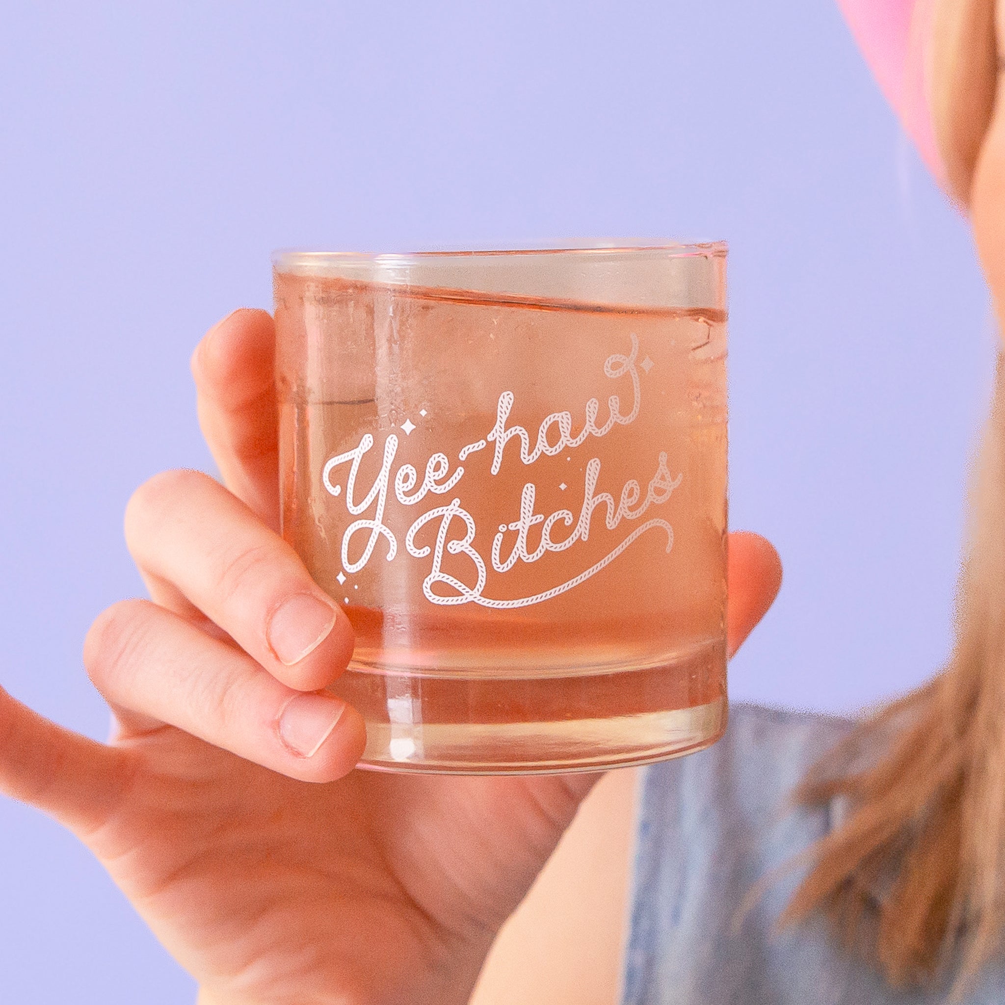 A short glass tumbler with white screenprinted text that reads, &quot;Yee-haw Bitches&quot;.