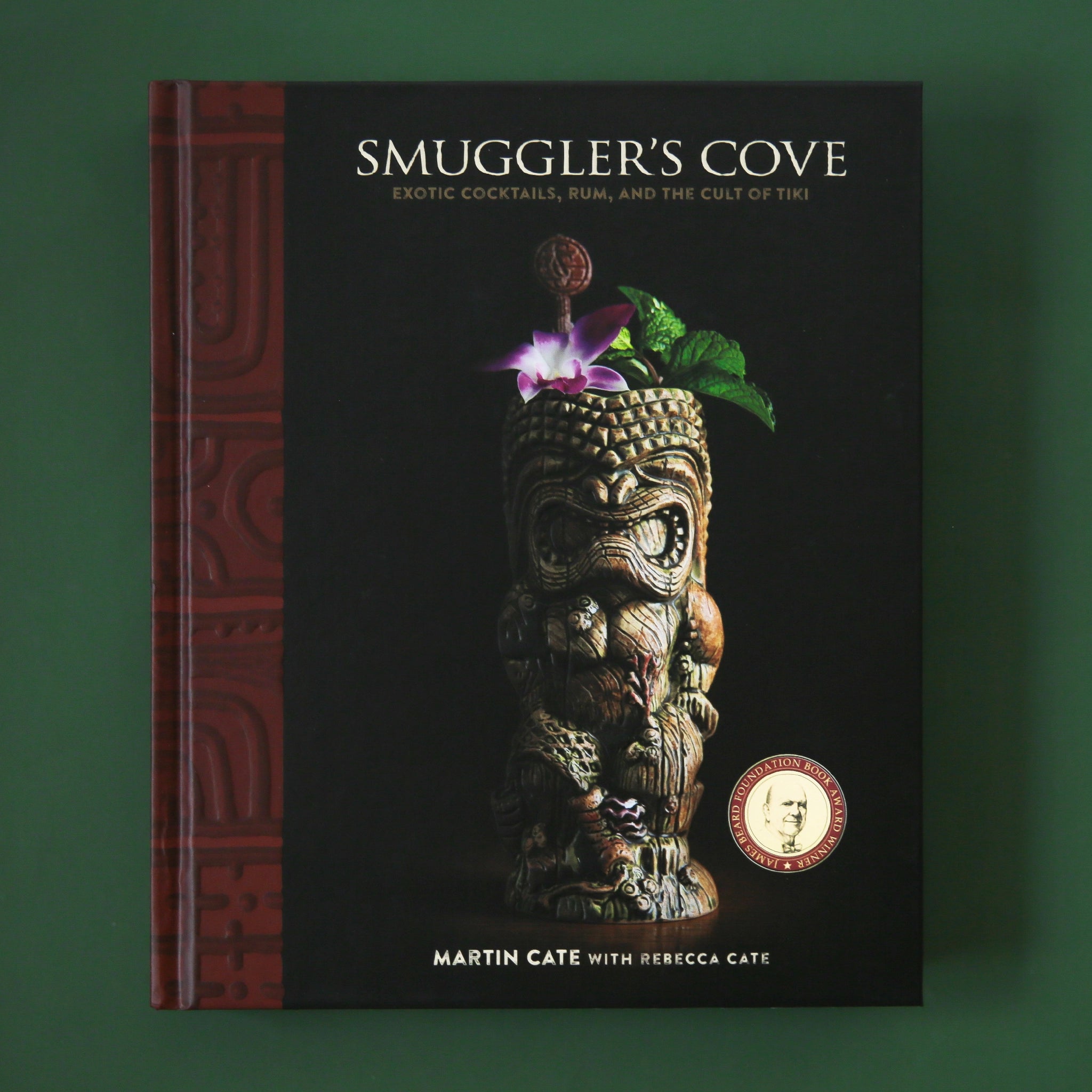A book with a black cover that has a carved tiki on the front along with the title, "Smuggler's Cove, Exotic Cocktails, Rum and the Cult of Tiki".