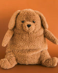 On an orange background is a snuggly brown stuffed animal dog with sleepy eyes and a chunky figure.