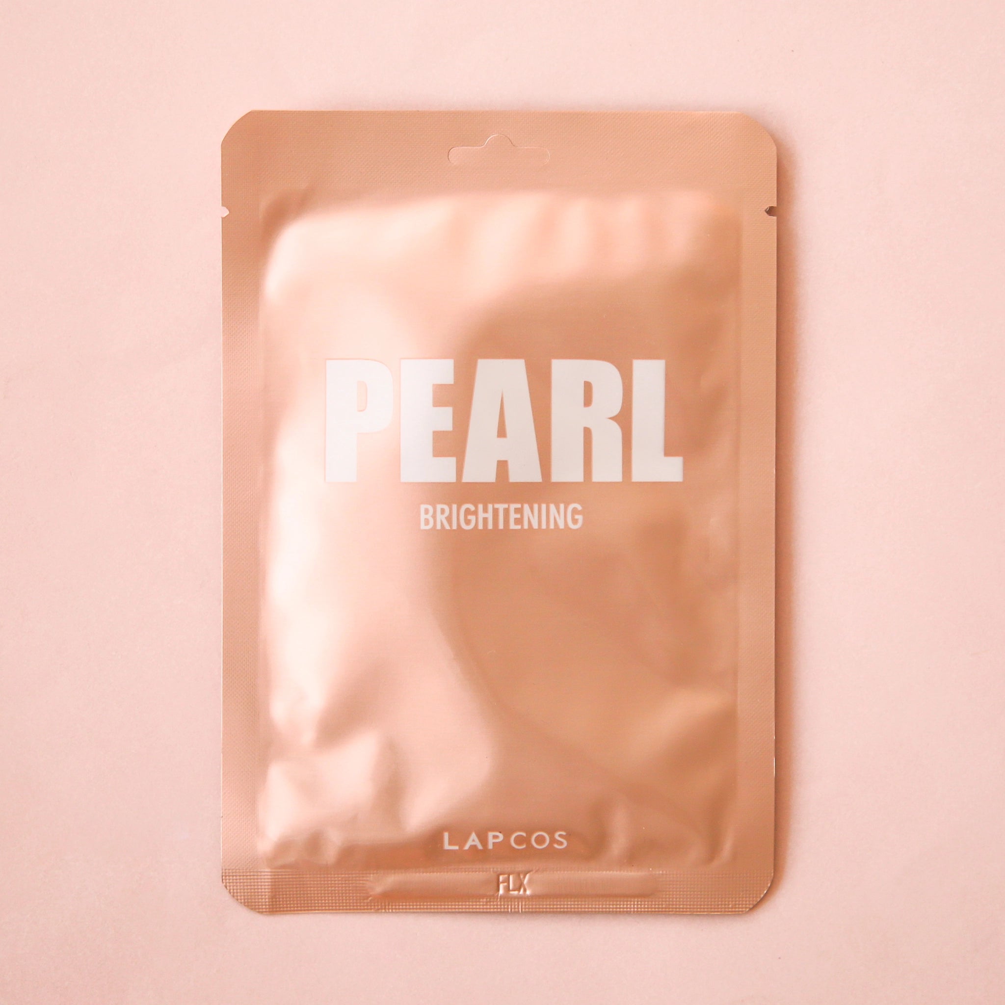 A rose gold pouch containing a face mask reads, &quot;Pearl Brightening&quot;.