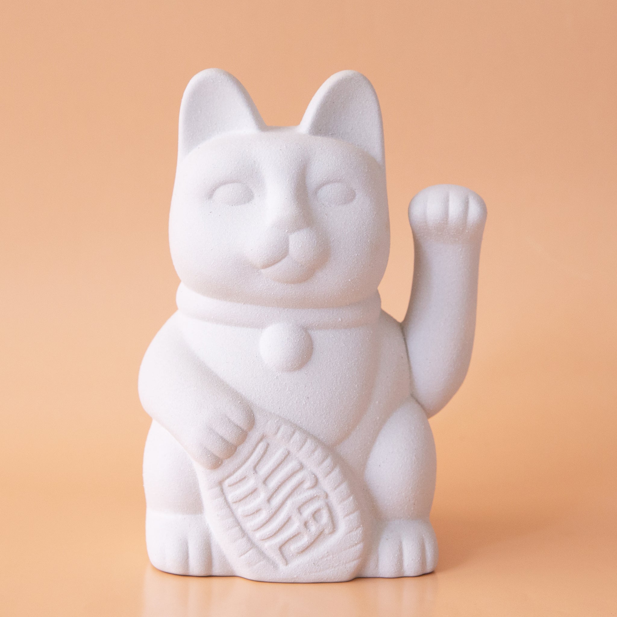 A ceramic lucky cat vase in white with its paw up in the waving position.
