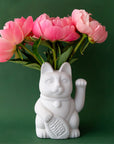A ceramic lucky cat vase in white with its paw up in the waving position staged here with natural dried florals.