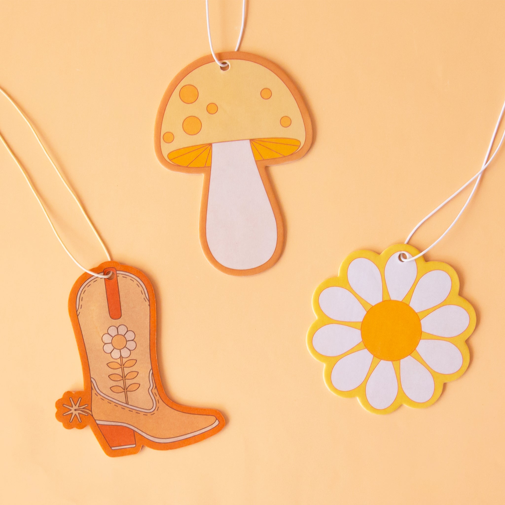 A group photo of the different shaped air fresheners we have available including a cowboy boot, daisy and mushroom. 