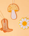 A group photo of the different shaped air fresheners we have available including a cowboy boot, daisy and mushroom.
